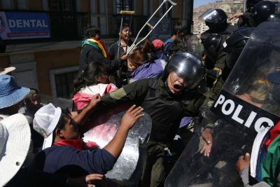 Manifestantes discapacitados chocan con la policía en el centro de La Paz, el martes 3 de mayo de 2016. Discapacitados bloquearon una avenida de La Paz el martes y colgaron a una mujer en silla de ruedas desde un puente tras una semana manifestaciones callejeras en reclamo de que el gobierno de Evo Morales mejore sus pensiones.(AP Foto/Juan Karita)