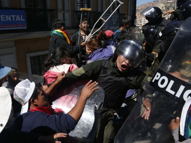 Manifestantes discapacitados chocan con la policía en el centro de La Paz, el martes 3 de mayo de 2016. Discapacitados bloquearon una avenida de La Paz el martes y colgaron a una mujer en silla de ruedas desde un puente tras una semana manifestaciones callejeras en reclamo de que el gobierno de Evo Morales mejore sus pensiones.(AP Foto/Juan Karita)