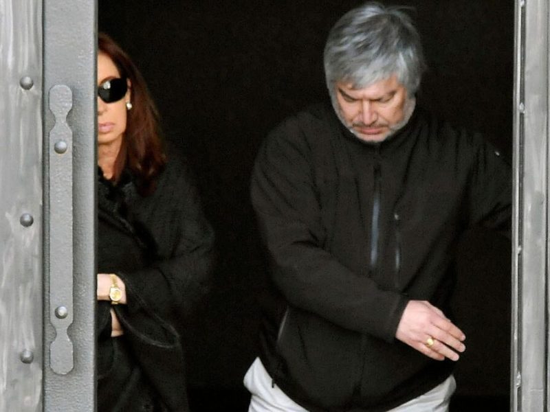 In this Feb. 18, 2013 photo, Argentina's President Cristina Fernandez, left behind door, accompanied by businessman Lazaro Baez, leaves the family's tomb at the cemetery in Rio Gallegos, Argentina, after the burial of the mother of late President Nestor Kirchner. An Argentine lawmaker asked on April 15, 2013 for an investigation into alleged corruption and money laundering by Baez that involved Kirchner. (AP Photo/Francisco Munoz, OPI Santa Cruz)